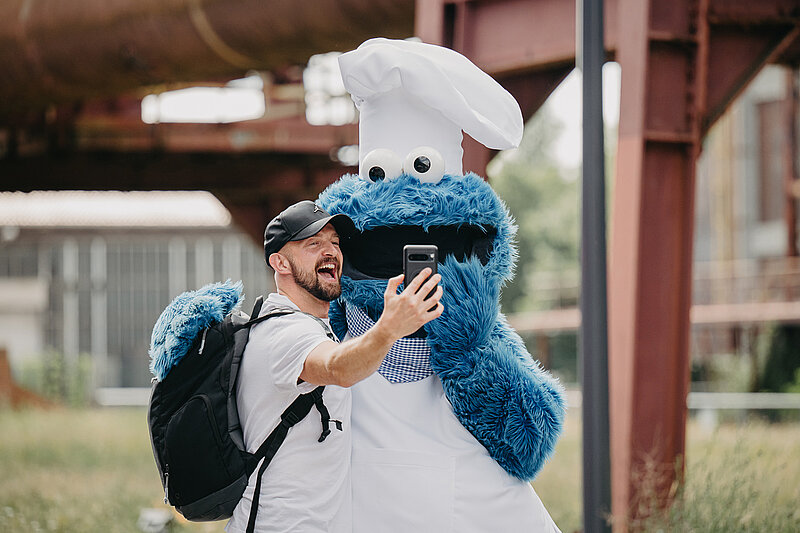 Ein Mann macht ein Selfie mit dem Krümelmonster